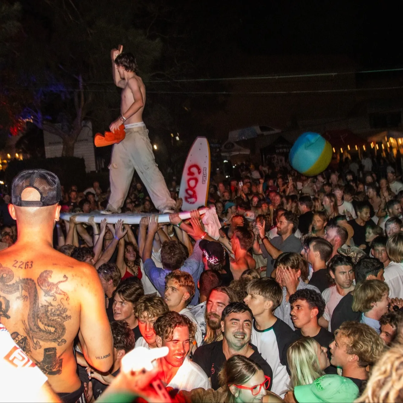 Black-and-white crowd at Good Day Out, a surfboard raised overhead