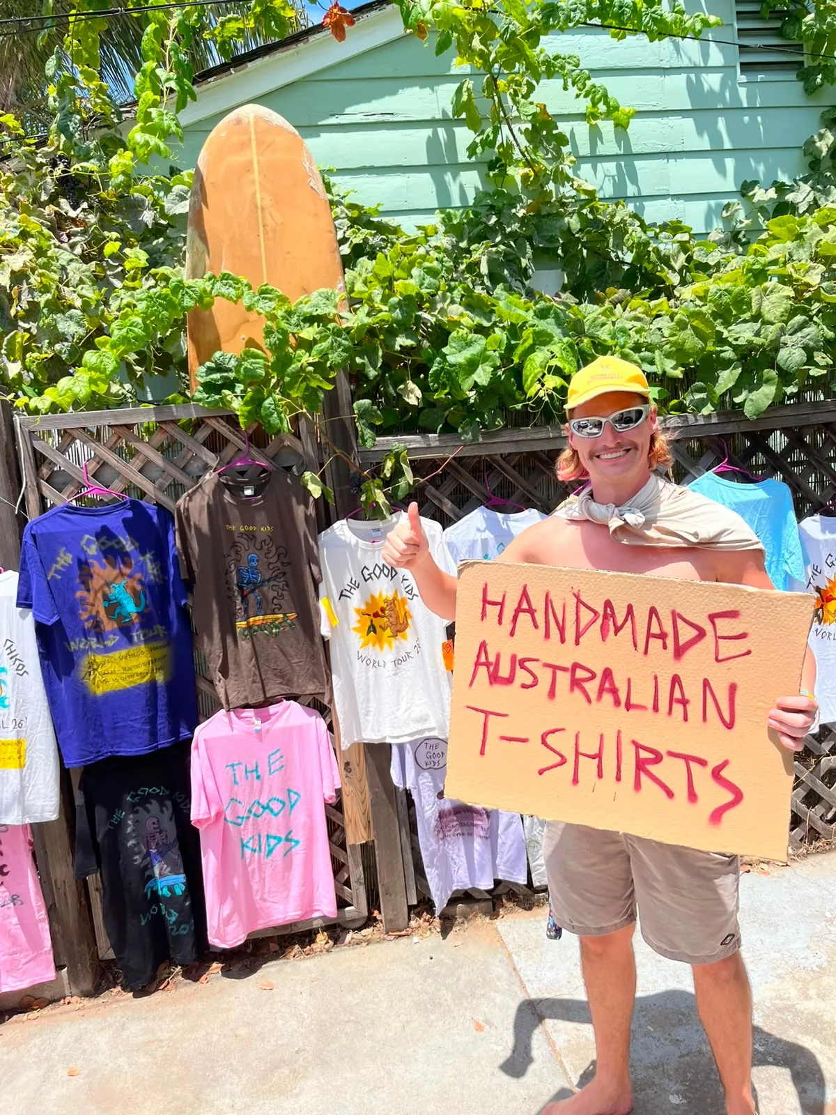 A hand-painted sign reading Handmade Australian T-shirts beside a rack of painted tees