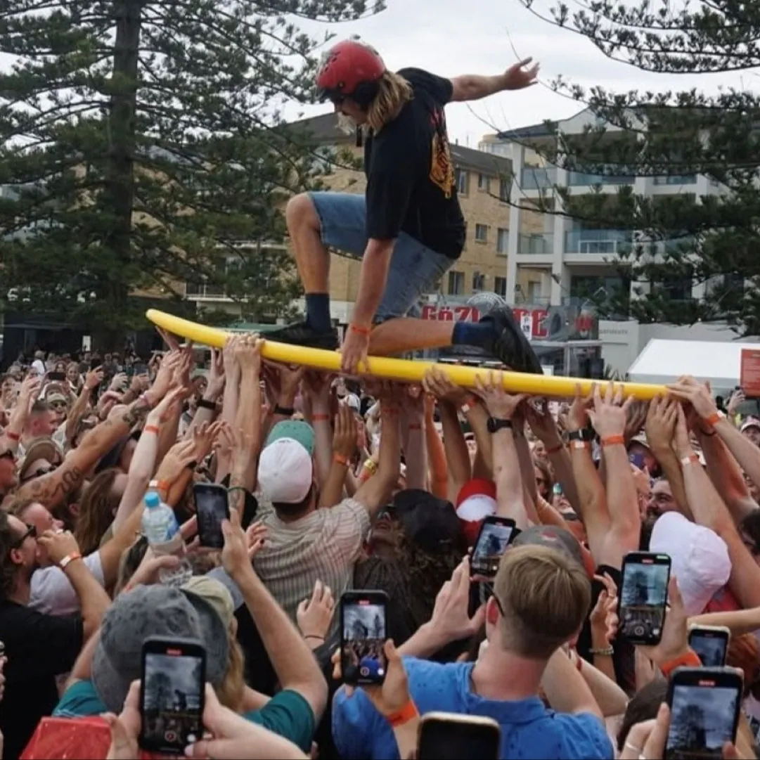 A Good Kid surfs the crowd on a yellow board at Rolling Sets